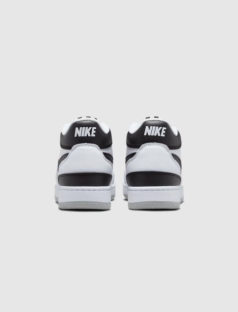 Back view of black and white low-top Nike sneakers on plain background