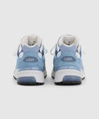 Back view of light blue New Balance sneakers with USA detail and white midsoles