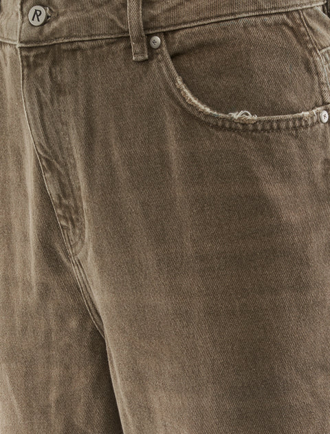 Close-up of brown corduroy pants with frayed pocket detail and metal button