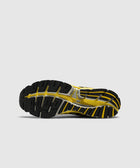 Yellow and black sneaker outsole with textured rubber grip against a light background