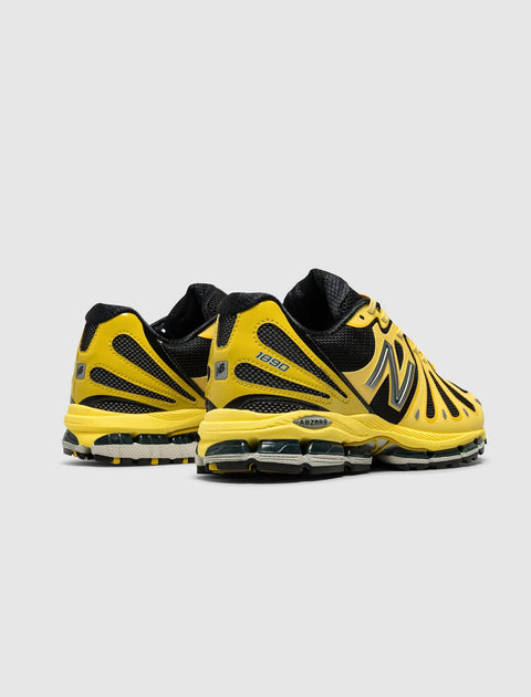 Yellow and black athletic sneakers with mesh panels and chunky sole, rear angle view