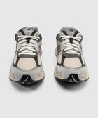 Pair of grey and beige mesh sneakers with white laces, front view on white background