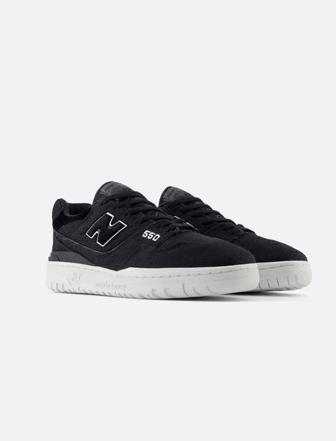 Black low-top sneakers with white soles and '550' detail on the side