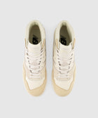 Beige high-top sneakers with white laces and perforated toes, viewed from above