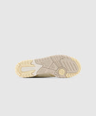Beige rubber sneaker sole with textured grip and engraved logo on a light background