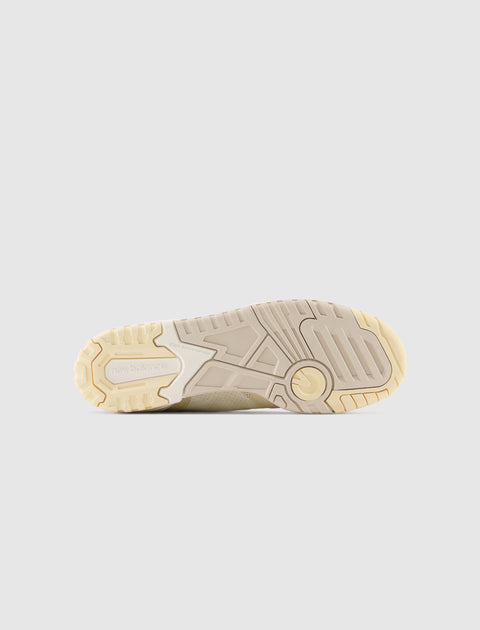 Beige rubber sneaker sole with textured grip and engraved logo on a light background