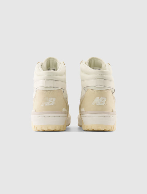 Rear view of beige high-top New Balance sneakers on a plain background