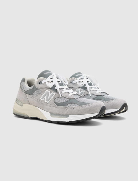 Men's grey athletic sneakers with suede and mesh panels, white laces, and cushioned soles.