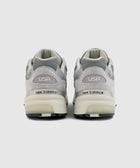 Rear view of grey New Balance sneakers with USA and 992 on heel, mesh and suede details