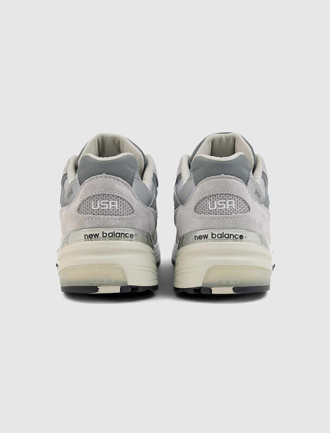 Rear view of grey New Balance sneakers with USA and 992 on heel, mesh and suede details