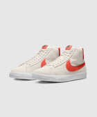 Light grey high top sneakers with orange swoosh accents and white textured soles on a plain background
