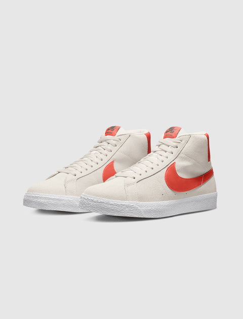 Light grey high top sneakers with orange swoosh accents and white textured soles on a plain background