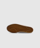 Gum sole detail of a streetwear sneaker with herringbone tread on grey background