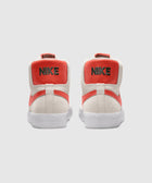 Rear view of white and orange high-top Nike sneakers with embroidered logo on heel
