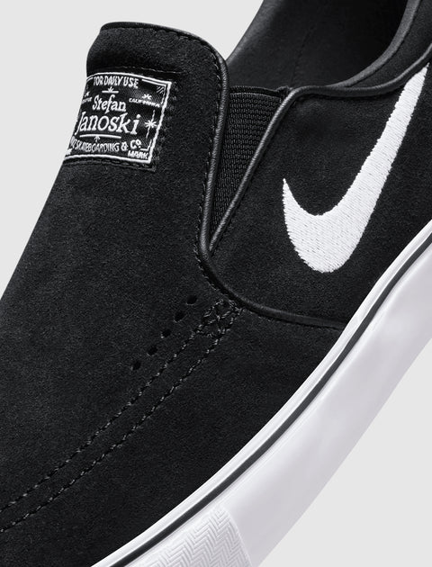 Black slip-on skate shoe with white swoosh logo, suede upper, and white rubber sole