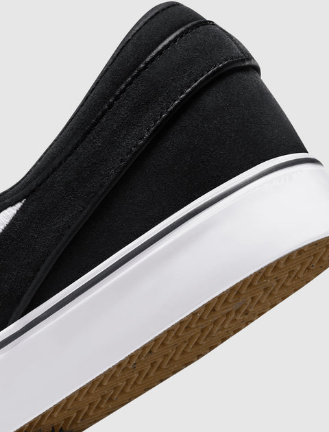 Close-up of black suede slip-on sneaker with white sole and gum outsole