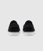 Back view of black slip-on sneakers with white soles on a plain gray background