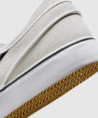 Close-up of white suede slip-on sneaker heel with gum sole and textured details
