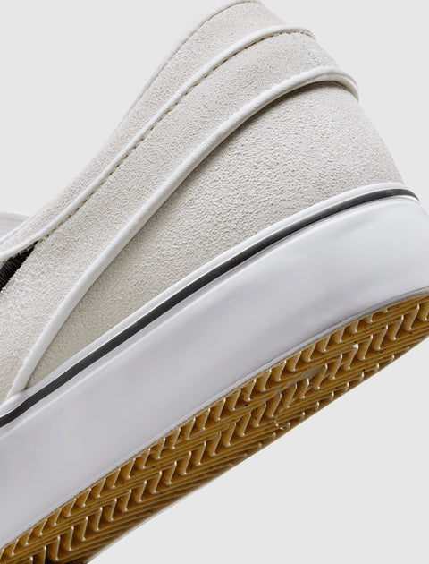 Close-up of white suede slip-on sneaker heel with gum sole and textured details