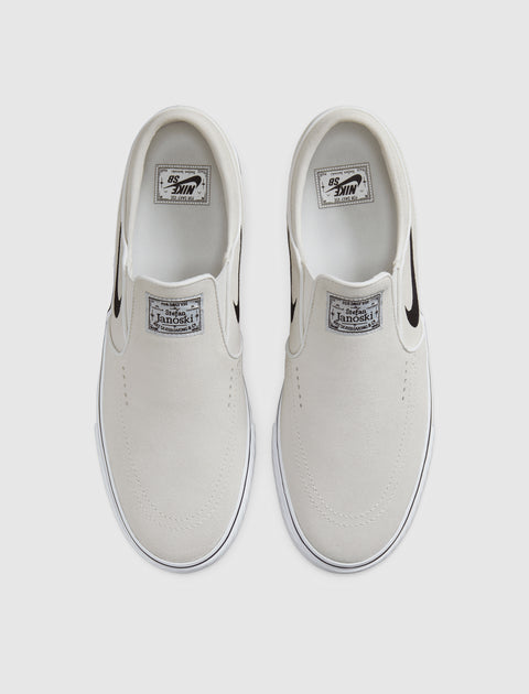 White slip-on skate shoes with black Swoosh logo, top view on plain background