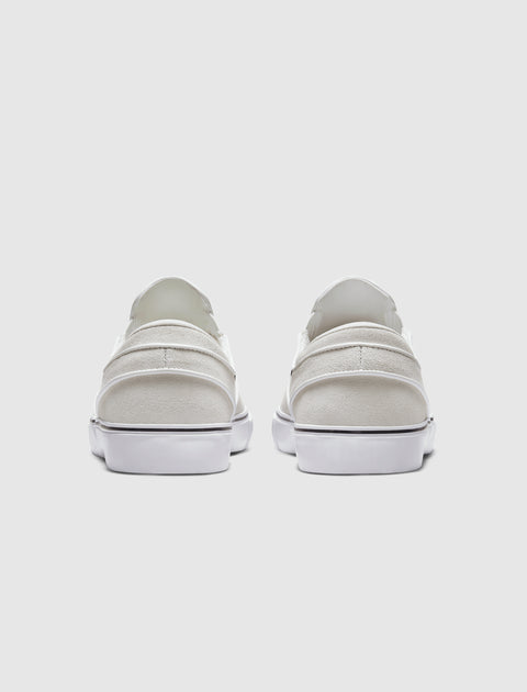 Rear view of white slip-on sneakers with white soles on a plain background