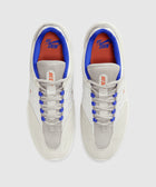 White and grey low-top sneakers with blue and orange accents, viewed from above