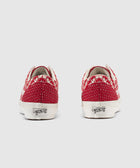 Back view of red and white patterned low-top sneakers with white soles on gray background