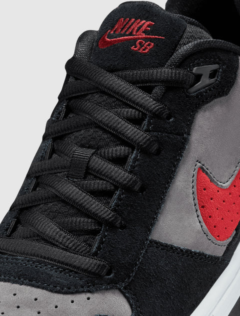 Close-up of black and grey suede sneaker with red Nike SB logo and red swoosh