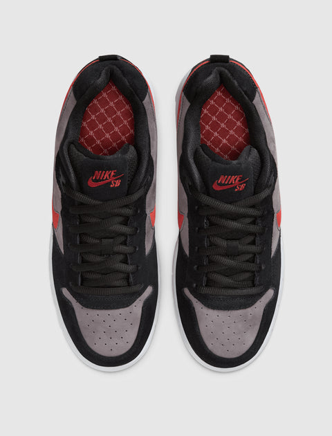 Top view of black and grey suede sneakers with red accents and Nike SB logo