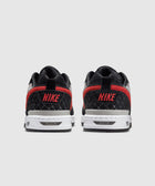 Back view of black and red Nike low-top sneakers with white soles on gray background
