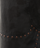 Close-up of black denim fabric with bronze rivets and subtle camouflage pattern