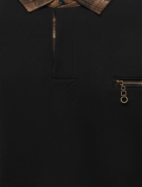 Close-up of black streetwear shirt with plaid collar and front zip pocket detail