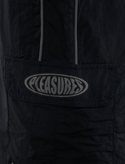 Black nylon streetwear jacket pocket with bold Pleasures logo and reflective trim detail