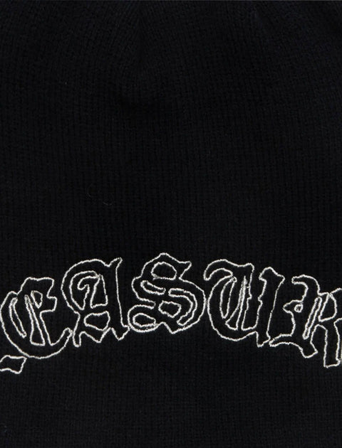 Black knit beanie with white embroidered gothic-style lettering detail