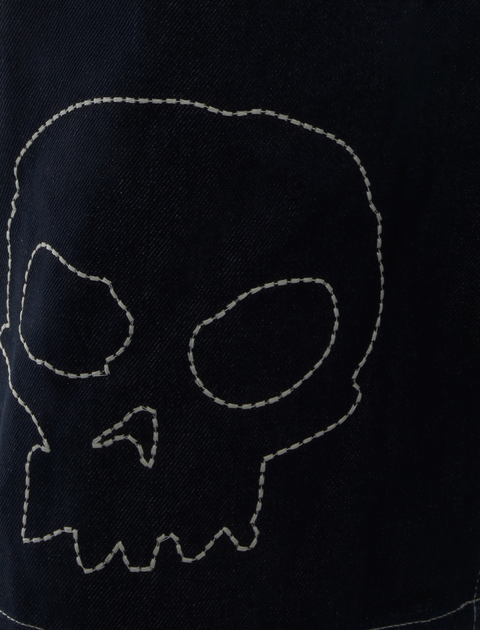 Dark denim fabric with white stitched skull outline, streetwear style detail