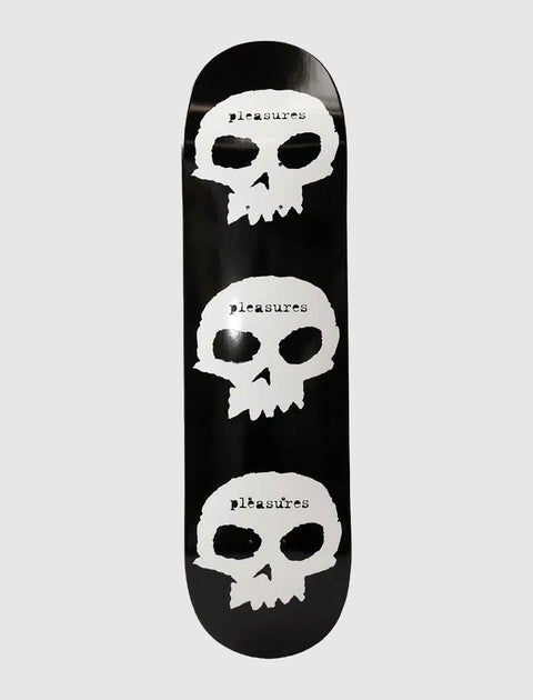 Black skateboard deck with three white skull graphics and pleasures text, streetwear accessory