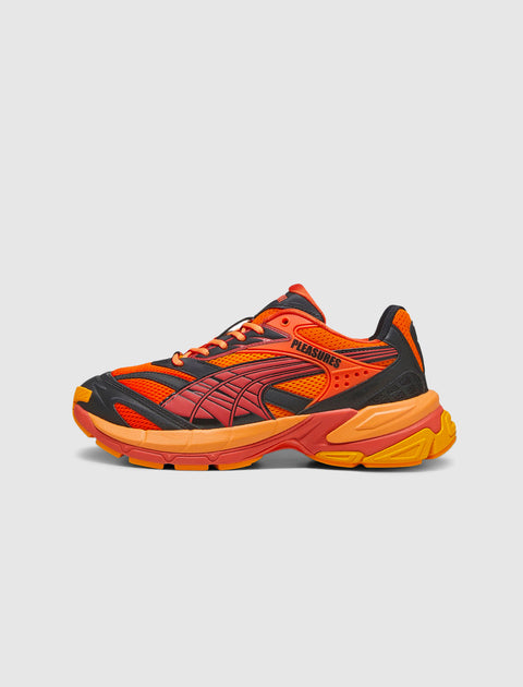 Red and orange mesh athletic sneaker with black accents and textured sole on white background