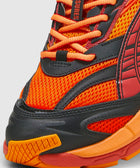 Close-up of vibrant orange and red mesh sneaker with black overlays and thick textured sole