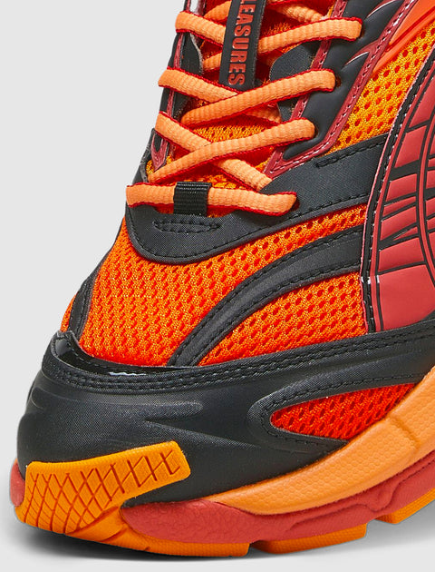 Close-up of vibrant orange and red mesh sneaker with black overlays and thick textured sole