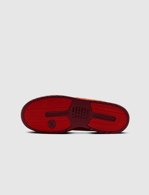 Red sneaker sole with textured grip and basketball logo, streetwear footwear