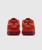 Back view of red and gold low-top Nike sneakers with quilted texture on heels