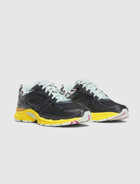 Black mesh athletic sneakers with yellow soles, light mint laces, and colorful accents
