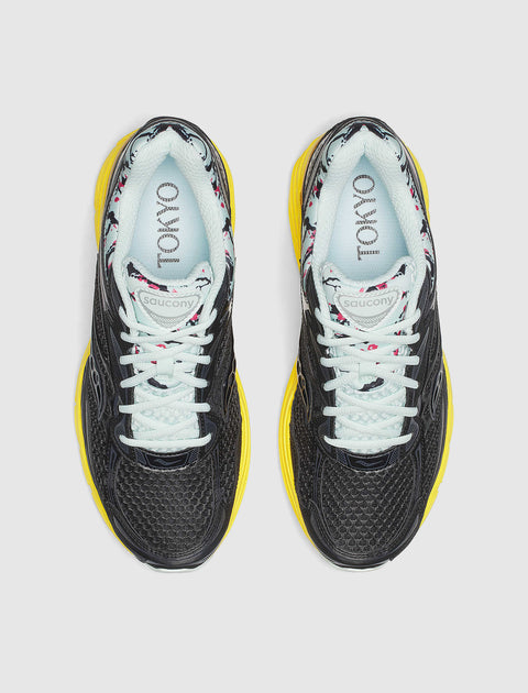 Top view of black mesh sneakers with yellow soles, white laces, floral lining, and TOKYO text