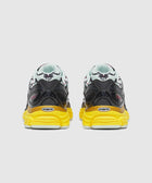 Rear view of black and white sneakers with yellow soles and graphic heel design
