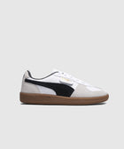 White and black suede low-top sneaker with gum sole on plain background