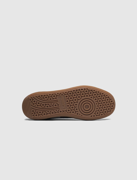 Gum rubber sneaker outsole with circular grip pattern and embossed logo on white background
