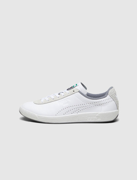 White low-top sneaker with perforated sides, suede accents, and grey detailing on heel
