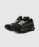 Black running sneakers with white laces and sleek white side detailing on a neutral background