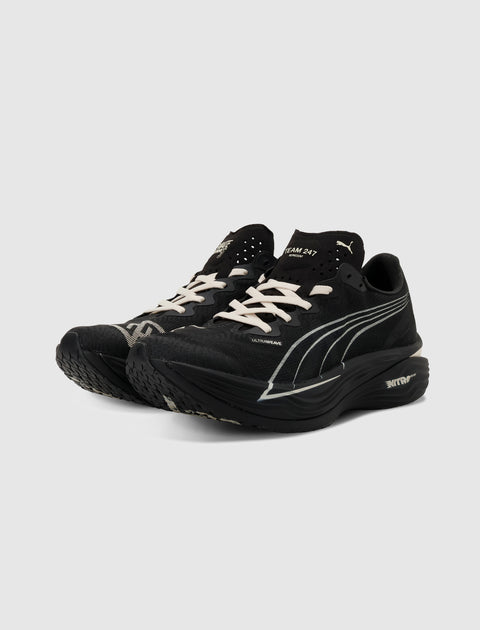 Black running sneakers with white laces and sleek white side detailing on a neutral background