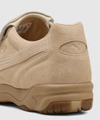Close-up of beige suede men's sneaker with textured sole and visible side stitching
